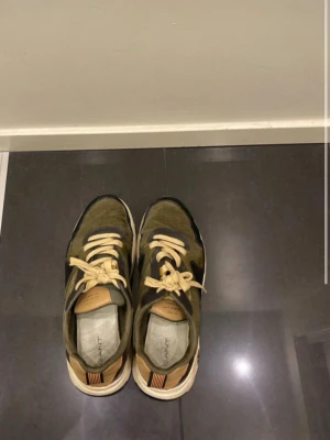 Gröna sneakers från Gant - Chunky sneakers från Gant i grönt, beige och svart med vita sulor. Ovandelen är i mocka och textil, med beige detaljer och snören. Snygg retrostil med robust sula och diskret logga på hälen. Perfekta för dig som gillar streetwear och vill sticka ut.