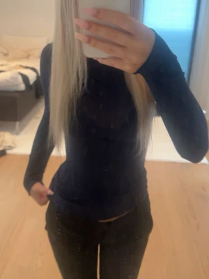 Mörkblå långärmad topp - Snygg mörkblå långärmad topp med tight passform. Enkel och stilren design utan synliga detaljer eller mönster, perfekt att matcha med olika outfits. Materialet känns mjukt och stretchigt för en bekväm känsla.