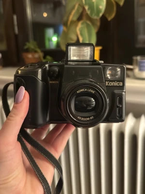 Konica Z-up 80rg, analog kamera, 35mm - Säljer en kamera som jag inte hunnit använda, den behöver ett nytt batteri men ser i övrigt väldigt fin och ren ut. Har inte testat den själv, därav priset, men jag tror att den fungerar, kan inte lämna garanti. Har haft en liknande kamera jag fotat mycket med och den tog väldigt fina bilder. Perfekt att ha med på festival eller liknande för fina old school bilder