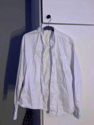 Klassisk vit skjorta  - En stilren vit skjorta med lång ärm och klassisk krage. 