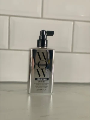 Color Wow Dream Coat Extra Strength - Color Wow Dream Coat Extra Strength är en hårbehandling i en silverfärgad, rektangulär pumpflaska. Produkten är framtagen för att ge ett ultralätt, fuktavvisande skydd och slätare hår. Flaskan rymmer 200 ml och har en modern, spegelblank finish.