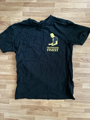 Svart t-shirt Fruängens Finest - helt svart med gult tryck på. Isherwood på bröstet. gammal aik tröja nu mera elfsborg tröja. perfekt till ett elfsborg fan som älskar isherwood. köpt i höstas och aldrig använd. pris går att diskutera!