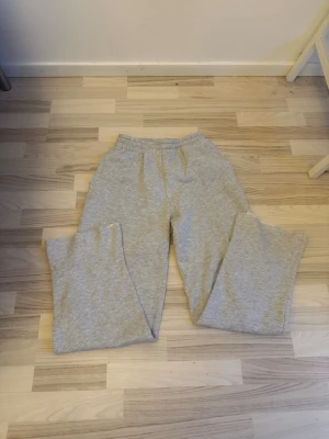 Grå mjukisbyxor med raka ben - Säljer ett par grå mjukisbyxor med elastisk midja och raka ben. Perfekta för chill dagar och har en enkel, klassisk design. Materialet är mjukt. Passar dig som gillar basic och avslappnat.