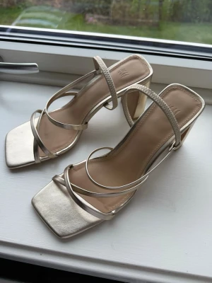 Klackskor - Guldiga bekväma klackar från H&M, använda 2-3 ggr. Säljer då de är för stora för mig. Finns vissa små skador vid klacken (se bilder) men är inget man ser när man har på sig dom
