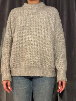 Grå stickad oversized tröja - Mysig grå stickad tröja med avslappnad passform och ribbade muddar vid ärmslut och nederkant. Från Zara storlek S 
