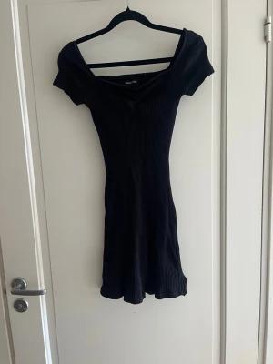 Svart kortklänning  - Svart kortklänning från even&odd i oanvänt skick. Klänningen har en figurnära passform och är tillverkad i ett stretchigt material som sitter snyggt på kroppen. Perfekt för en trendig och enkel look.