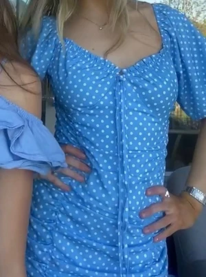 Blå sommar klänning - Söt blå kortklänning med vita prickar och offshoulder-design. Klänningen har puffiga kortärmar och snörning framtill som ger en feminin look. Perfekt för sommarens alla tillfällen. Materialet känns lätt och bekvämt. Dragkedja . Perfket miniklänning för mig som är 167