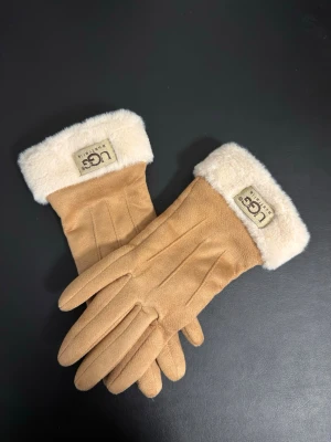 Ugg Australia handskor - Säljer eleganta UGG Australia damhandskar. Handskarna är mjuka, silkeslena och mycket varma, perfekta för kalla höst- och vinterdagar. Tidlös och stilren design som passar alla tillfällen.                                                         Färger: beige, svart, grå och rosa.