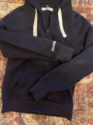 Russemerch hoodie - Mysig mörk blå hoodie från russemerch, hoodien är i jättebra skick/ nästan helt ny. Säljer hoodien för att jag har trötnat på den.