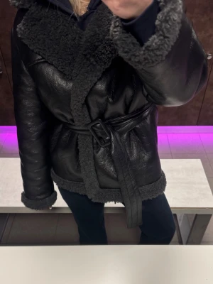 Svart teddyjacka med bälte - Svart teddy jacka/ skinn från Gina Tricot