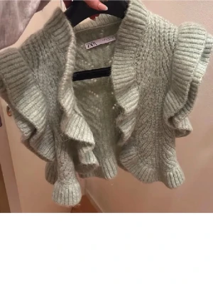 Stickad Bolero Zara - Snygg grön stickad bolero med volangdetaljer. Perfekt för att lägga till en mysig touch till din outfit. Storlek S