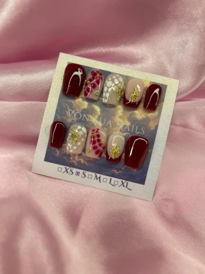 LoveSpell(S); Short Ballerina  - Snygga handgjorda press-on naglar i vinrött, nude och vitt med coola detaljer som guldstjärnor, pärlor och handmålade mönster. Perfekt för dig som vill ha unika naglar med wow-effekt. S: 15 mm, 11,5 mm, 12 mm, 11 mm, 9 mm 