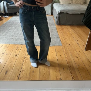 Blå baggy jeans från Diesel - Säljer ett par blå jeans från Diesel med snygg baggy passform. Har en reva där uppe som lätt kan sys. Har vikt upp de på bilden då de är för stora på mig. Jag är en storlek S. Står storlek 30 på lappen