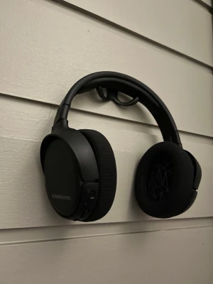 SteelSeries gaming headset trådlöst– mycket bra skick – USB-C – perfekt till PS5/PC - Snyggt svart gamingheadset från SteelSeries med mjuka öronkuddar, justerbar bygel och avtagbar mikrofon. Headsetet är trådlöst och kommer med USB-dongle och laddkabel, perfekt för gaming på PC eller konsol. Varsamt använda och fungerar felfritt. Köpta för 1300kr