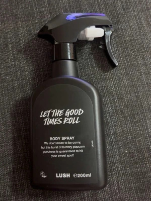 LUSH Let The Good Times Roll Body Spray 🍿 - LUSH Let The Good Times Roll Body Spray i svart plastflaska med spraymunstycke. Doften beskrivs som en explosion av smörig popcorn-goodness. Flaskan rymmer 200 ml och har en modern, stilren design med vit text på framsidan. HELT OANVÄND !