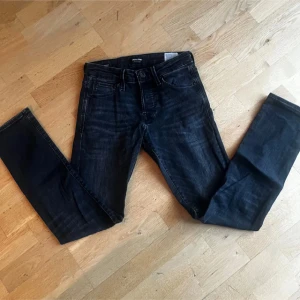 Mörkblå slim fit jeans från Weekday - Säljer ett par mörkblå slim fit jeans från Weekday med klassisk femficksdesign och knappgylf. Jeansen har en snygg tvättad look och raka ben. Perfekta för dig som gillar en enkel men stilren stil.