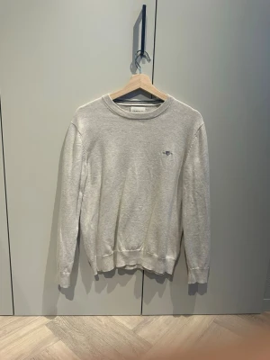Ljusgrå sweatshirt från GANT - En stilren ljusgrå sweatshirt från GANT med rund halsringning och diskret broderad logga på bröstet. Tröjan har långa ärmar och ribbade muddar vid ärmslut och nederkant. Perfekt basplagg i mjukt bomullsmaterial.