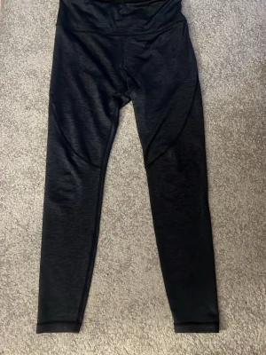 Svarta leggings från Energetics - Snygga mörkgråa leggings från Energetics med hög midja och smal passform. Tillverkade i ett stretchigt och mjukt material som passar perfekt till träning eller chill. Diskreta sömdetaljer längs benen för en sportig look.