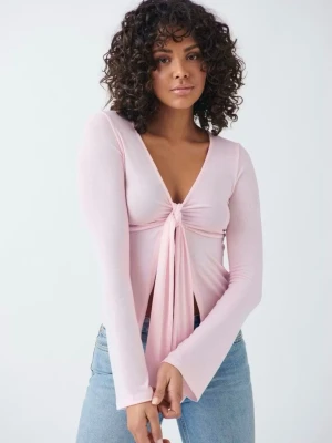 Ljusrosa långärmad topp med knyt - Supersöt ljusrosa topp med lång ärm och v-ringning. Toppen har en snygg knyt-detalj framtill som ger en trendig look. Perfekt att styla med jeans eller kjol för en chill vibe.