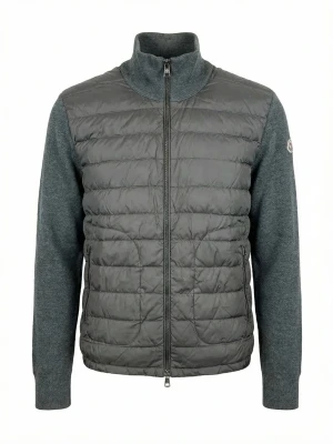 Grå dunväst från Moncler - Snygg grå dunväst från Moncler med quiltad front och stickade ärmar. Hög krage, hel dragkedja och två sidofickor med dragkedja. Moncler-logga på vänster ärm. Perfekt för lager-på-lager och stilren look.