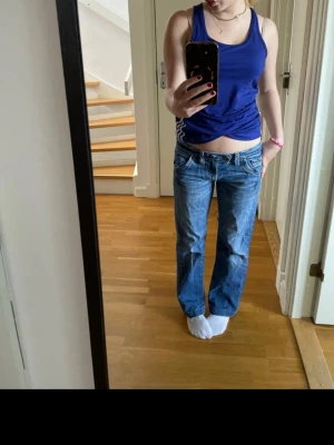 Blå raka miss sixty jeans med låg midja - Säljer ett par blå jeans med låg midja och raka ben. Jeansen har klassisk femficksdesign och är tillverkade i denim. Perfekta för en avslappnad och trendig look. Dock är den ena fickan trasig men ingenting som jag har tänkt på. Midjemått är: 40cm och innerbenslängd: 67cm❤️