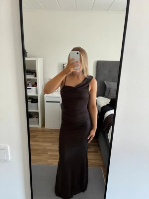 Mörkbrun långklänning   - Snygg mörkbrun balklänning från Showpo! Klänningen har en tight passform och är tillverkad i ett mjukt, stretchigt material. Säljer den då jag hittat en annan balklänning. Prislappen är kvar och aldrig använd! 
