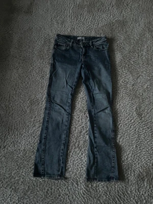 Ljusblå bootcut jeans - Snygga ljusblå bootcut jeans med klassisk femficksdesign och broderade detaljer på bakfickorna. Jeansen har låg midja och raka ben, perfekta för en avslappnad och trendig look. Tillverkade i denim med lätt tvättad effekt. Passar som xs. 
