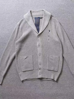 Grå Cardigan Polo Ralph Lauren - Stilren grå kofta från Polo Ralph Lauren med sjalkrage, knäppning framtill och två stora fickor. Ribbstickad struktur och diskret broderad logga på bröstet. Perfekt för lager-på-lager och en chill look. Passar M