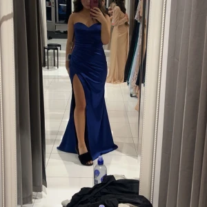 Balklänning ifrån Dressroom Linné - Säljer min snygga mörkblåa balklänning som är köpt ifrån Dressroom Linné i Göteborg, säljer pågrund av att jag hittat en annan balklänning jag vill ha istället💕Den är helt ny och oanvänd samt att alla lappar sitter kvar!! När ni köper ingår även ett klädöverdrag till klänningen för att skydda den😊Klänningen är i storlek 10 vilket är ca 38/M, den sitter bra på mig som brukar ha S/M💕Köpt på rea för ca 1500 kr😊Det är bara att skriva om ni har frågor eller vill ha fler bilder!!