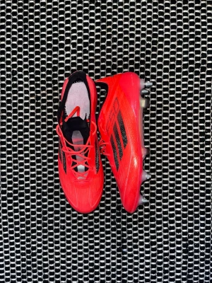 Adidas F50 Elite - Säljer 1 tränings använda fotbollsskor som jag har fått. Skorna är röda med glitter typ design. Skorna har järndobbar för dom är gjorda för mjukmark/gräs (SG), bra att ha extra par sulor där han tog bort sulorna från skorna. Pris kan självklart diskuteras. Ps det är en fotbollsspelare.