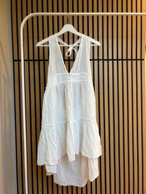 Vit halterneck klänning- Calzedonia Cobey - Vit sommarklänning från Calzedonia Cobey i storlek xs/s. Klänningen är gjord av 100% bomull, vilket ger en luftig och avslappnad feeling då materialet andas. Perfekt som sommarklänning och strandklänning! Vid frågor, tveka inte att höra av dig!🌸