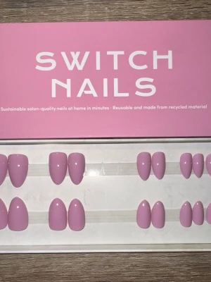 Switch Nails Mauve Over Almond Short - Press-on naglar från Switch Nails i modellen Mauve Over. Naglarna har en snygg mauve-lila färg och kommer i en kort almond-form. Tillverkade av återvunnet material och kan återanvändas. Perfekt för dig som vill ha salongskänsla snabbt hemma. Säljes utan tillbehör.