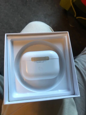 Apple AirPods Pro 2med laddningskabel - Säljer ett par Apple AirPods Pro med vitt laddningsetui. Hörlurarna är trådlösa in-ear och har en stilren, kompakt design i blank vit plast. Perfekta för dig som vill ha grymt ljud och smidig anslutning till din iPhone eller andra Apple-enheter.