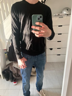 Svart basic tröja i bomull - En enkel svart långärmad tröja med rund halsringning från Singular Society. Tröjan har en rak passform och är tillverkad i mjukt bomullsmaterial. Perfekt att matcha med jeans eller under en jacka för en clean look.