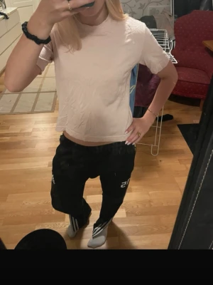 Ljusrosa t-shirt - En enkel och stilren ljusrosa t-shirt. T-shirten har korta ärmar och rund halsringning. Tillverkad i mjuk bomull som känns skön mot huden. Perfekt till jeans eller mjukisbyxor för en avslappnad look.