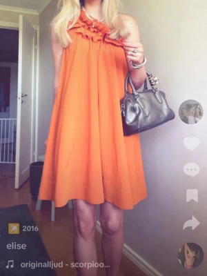 Orange one shoulder klänning H&M💘 - Snygg orange one shoulder klänning från H&M med volangdetalj upptill. Klänningen har en lös passform och är kort i modellen, perfekt för sommarens alla tillfällen. Tillverkad i ett lätt och luftigt material.