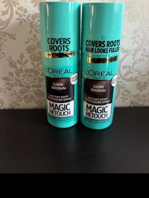 L'Oréal Magic Retouch Dark Brown - Två flaskor L'Oréal Paris Magic Retouch Instant Root Concealer Spray i färgen Dark Brown. Perfekt för att snabbt täcka utväxten mellan färgningar. Smidig sprayflaska i turkos plast med svart och guld detaljer.