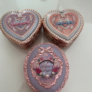 Flower knows rouge Bunny Garden och fairy - Rouge i hjärtformad ask med spegel, dekorerad med romantiska detaljer och roséguld. Finns i nyanser av rosa och persika. Från Bunnygarden kollektionen. vackert reliefmönster med blommor och rosetter. Perfekt för dig som gillar söta och unika sminkprodukter. Färgerna är: 04 Iris Garden, S01 Pink Doll och 03 i midsummer collection. Säljs endast som paket, så fina som dekor. Kan mötas upp i Göteborg 