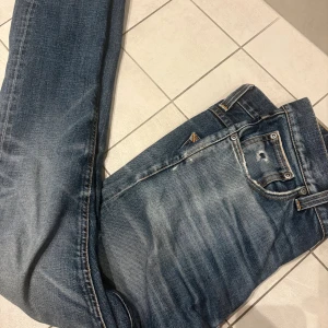 Nudie jeans Lean Dean - Säljer ett par blåa jeans från Nudie med slitnig vid benet 