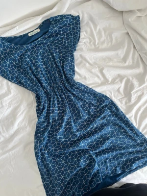 Blå kortklänning från kalimera  - Blå kortklänning från kalimera med vitt mönster. Klänningen har resår i midjan för en snygg passform och korta ärmar. Köpt i Grekland, passar mig som brukar ha XS-S. Perfekt till sommaren! Skriv vid frågor och pris kan diskuteras. Finns även på Vinted (samma användarnamn) 💞💞