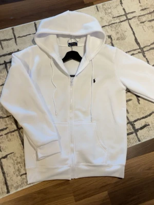 Ralp lauren Hoodie  - Säljer en vit Ralph Lauren som är i fanska bra skick i storlek M. Droppa hur lång du är och hur mycket du väger så kollar jag om det passar. Är det något du undrar skriv!