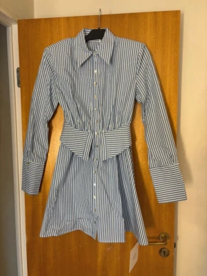 Adoore blåvit randig skjortklänning  - Jätte fin oanvänd Adoore klänning i storlek 36, men som tyvärr satt för tajt för mig i midjan. Så hade rekommenderat den till någon som har storlek 34 i vanlig fall.