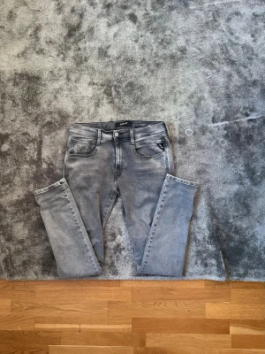 Gråa anbass jeans från repaly - Säljer ett par gråa snygga jeans från replay de är som nya. Sitter som ett smäck riktigt schyssta. 