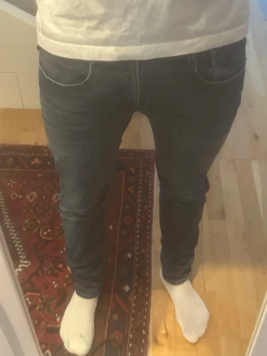 Mörkblå replay anbass - Säljer ett par mörkblå skinny jeans med klassisk femficksdesign och smal passform. Jeansen har normal midja och är tillverkade i stretchigt denimtyg för extra komfort. Perfekta för dig som gillar en tajt look.