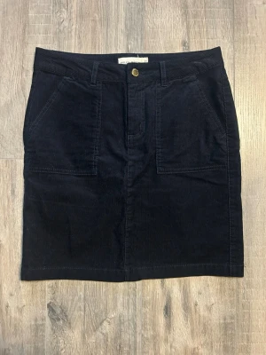 Holly & Whyte svart manchesterkjol mini vintage 36 S - Svart manchesterkjol från Holly & Whyte by Lindex 🖤 Klassisk mini i ribbad manchester med hög midja och fickor fram. Sitter snyggt och passar till både preppy och vardagslook.  • Märke: Holly & Whyte  • Storlek: 36 (S) • Färg: Svart • Material: Manchester / corduroy • Skick: Mycket bra • Längd: ca 46 cm • Midja: ca 40 cm platt (se bild)