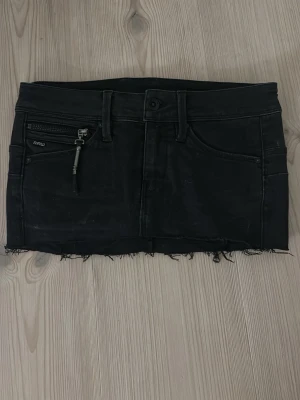 Svart jeanskjol från G-Star RAW - Snygg lågmidjade svart mini-jeanskjol från G-Star RAW. Storlek 24. Säljer då den inte passar. Skriv vid frågor!