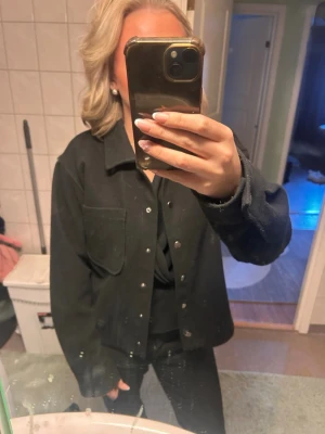 Svart overshirt med knappar - Storleken är 170 men passar XS-S. Använd vid fåtal tillfällen & säljer för att jag inte använder den! 
