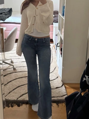 Blå bootcut jeans med tvättade detaljer - Låg midja bootcut