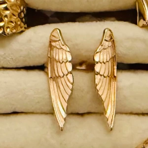 Guldring i form av vingar - Snygga ring i guldfärgad  formade som detaljerade änglavingar. Perfekta för dig som vill ha en unik och trendig accessoar som sticker ut. Örhängena har en elegant och stilren design som passar till många olika looks.