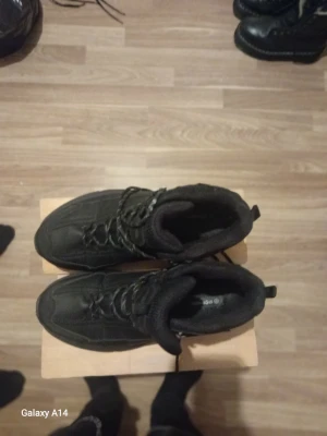 Svarta kängor med snörning - Säljer ett par svarta kängor med snörning och robust sula. Kängorna har en vadderad insida för extra komfort och dragflik bak för enkel påtagning. Perfekta för kalla dagar och har en sportig look.